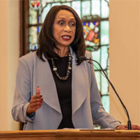 Carolyn Jefferson-Jenkins stands and delivers a speech from a podium in Kumler Chapel at Miami University. Text overlaid on the right of the image reads Carolyn Jefferson-Jenkins collection to be digitized thanks to Hawk Tank grant funding, and includes the M.I.A.M.I. WOMEN wordmark.